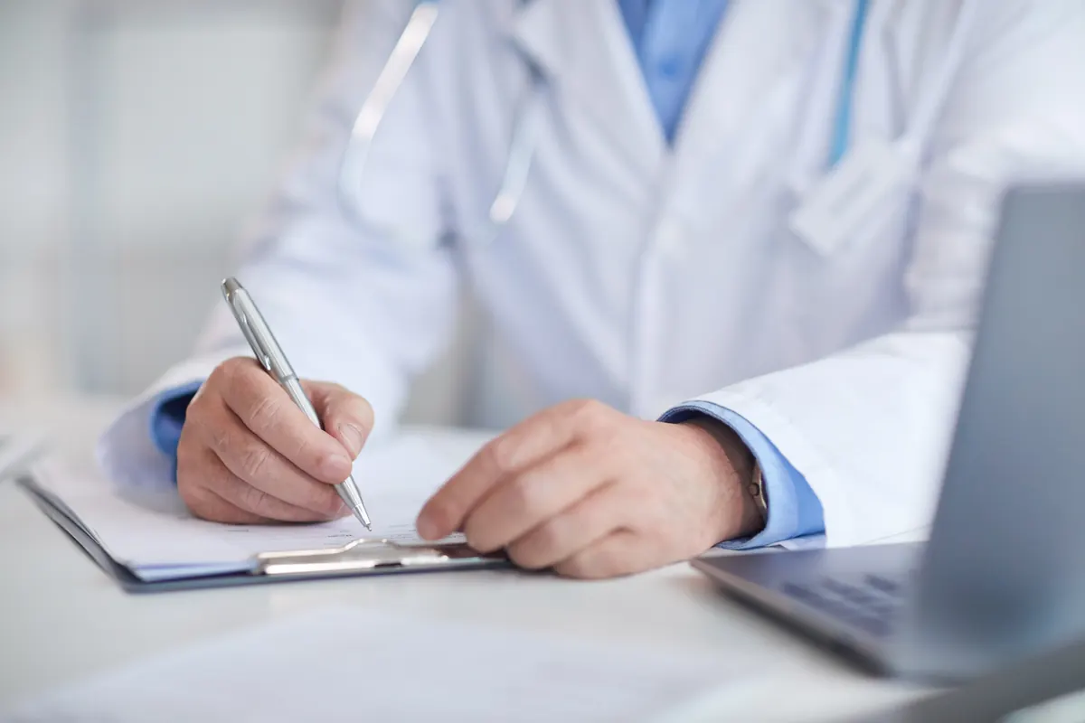 Medic completând documentele medicale ale unui pacient